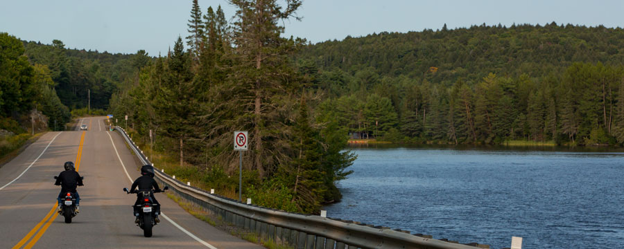 Motorcycle riding beside a lake.