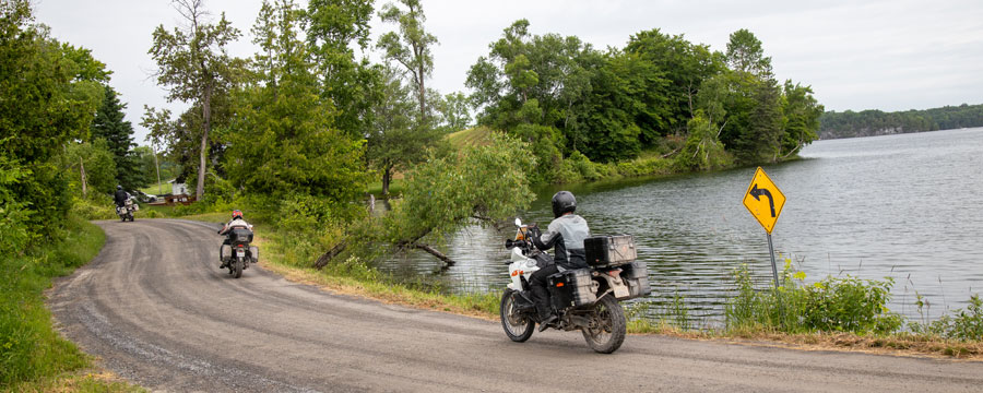 three motorcycles on a gravel road