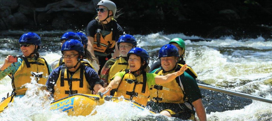 a raft going through rapids full of smiling rafters