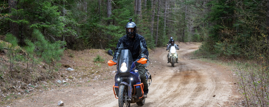 Two adventure motorcycles on a twisty gravel road.