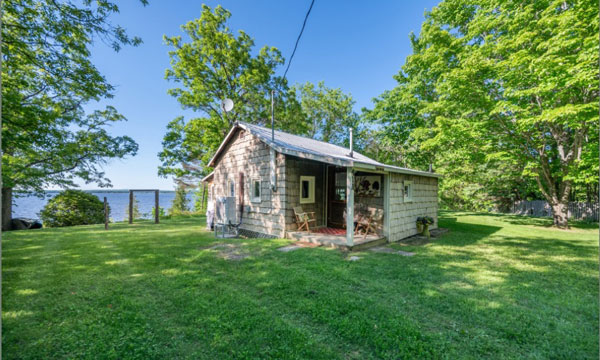 Exterior of cottage with lake behind