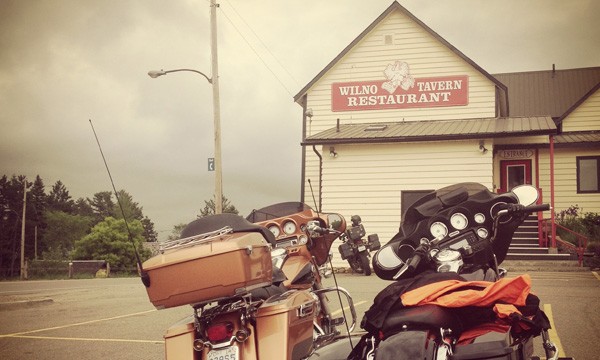 Two motorcycles in front of wooden building